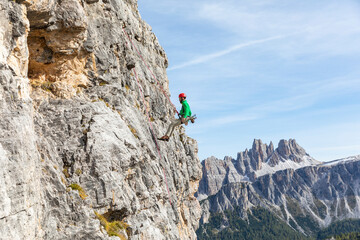 Italy, Cortina d'Ampezzo, man abseiling in the Dolomites mountains