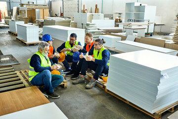 Workers in factory having lunch break together - obrazy, fototapety, plakaty