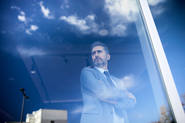 Portrait of a mature businessman behind windowpane