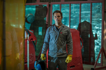Fototapeta na wymiar Portrait of confident man holding a welding mask in a factory