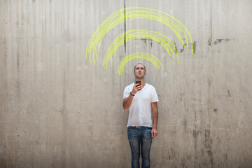 Man holding cell phone with yellow chalk wifi sign above his head
