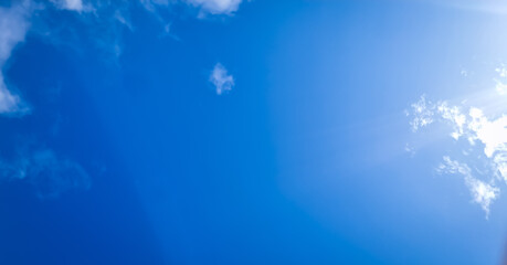 Blue sky background with tiny clouds. Blue sky sunrays with tiny clouds.