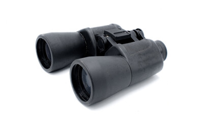 A pair of black rubber grip metal binoculars isolated on white background.  Well worn, used, dirty full of sand from being out in the field viewing wildlife.  Side Top view