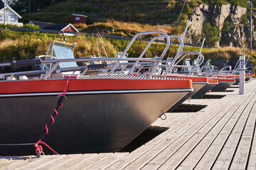 Aluminium fishing boats for sport fishing in the public pier in the norwegian willage in the fjord....