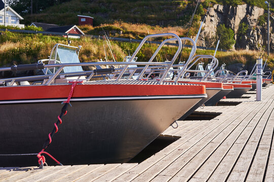 Aluminium fishing boats for sport fishing in the public pier in the norwegian willage in the fjord. Sport fishing is a part of culture in Scandinavia and popular outdoor all year activity in Norway.