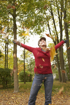 Woman Throwing Autumn Leaves in Air