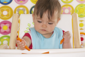 Baby in High Chair with Carrots