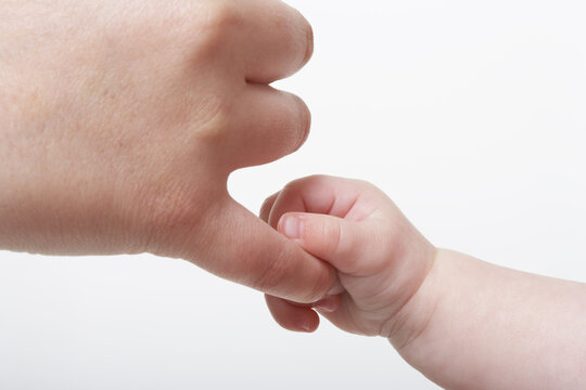 Naklejki Baby's Hand Holding Adult's Finger