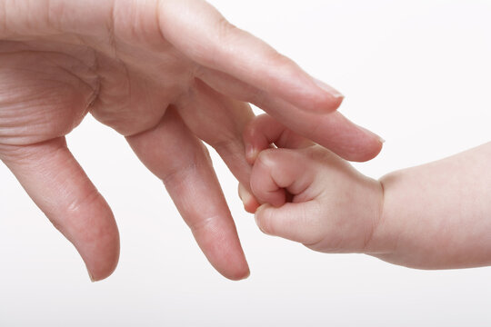 Baby's Hand Holding Adult's Finger