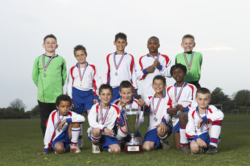 Portrait of Soccer Team With Gold Medals and Trophy