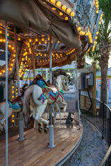 Fototapeta na wymiar A Merry-go-round with horses and seahorses with colorful lights and carnival rides along the boardwalk at the Carolina Beach Boardwalk in Carolina Beach North Carolina USA