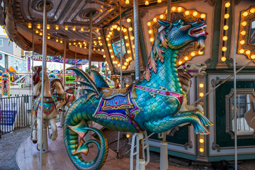 Fototapeta na wymiar A Merry-go-round with horses and seahorses with colorful lights and carnival rides along the boardwalk at the Carolina Beach Boardwalk in Carolina Beach North Carolina USA