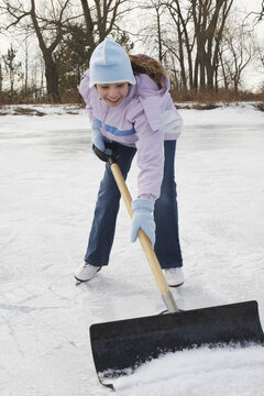 Girl Shoveling Snow from Rink