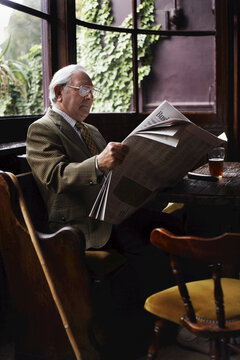 Man Reading Newspaper in Pub