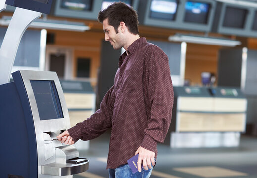 Man Using Ticket Machine in Airport