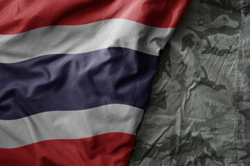 waving flag of thailand on the old khaki texture background. military concept.