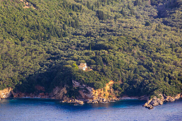 Fototapeta premium View in the evening under a blue sky over the bay and the sea near Paleokastrtitsa on the island of Corfu