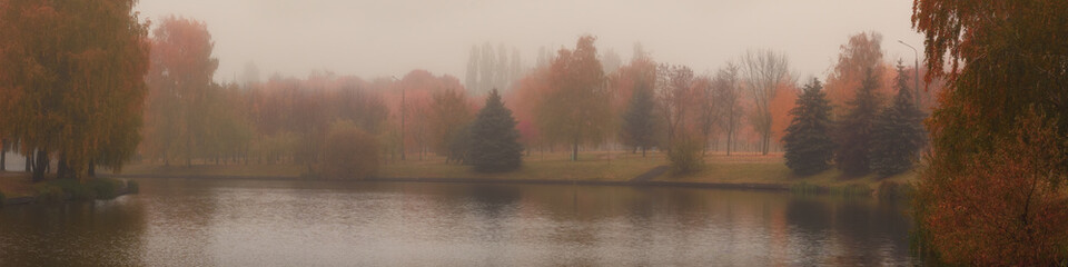 multicolor of late autumn. morning foggy city park along the river. beautiful widescreen panoramic side view with natural atmospheric blur. format 20x5