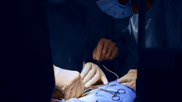 Hands of surgeon in latex gloves performing surgery. Metal instruments are used at neurosurgery. Close up.