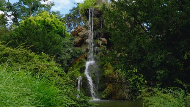 Rock Waterfall in the Bagatelle Park. The Park is located in Boulogne-Billancourt near Paris, France