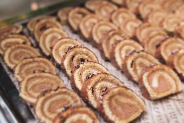 Beautiful multicolored decorated baked sweet tasty candy bar dessert selection with cake, pie and pastries catering banquet table on a kids children party, coffee break buffet at a conference