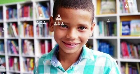 Animation of profile icons flowcharts over close up of smiling biracial boy standing in library - Powered by Adobe