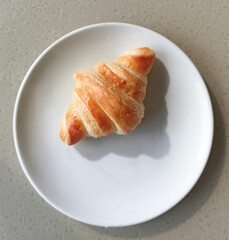 Delicious crusty croissants on a plate. 