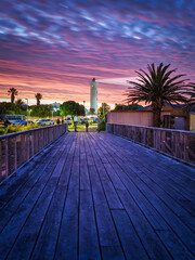 Vertical shot of the Wooden bridge leading to the Milnerton Lighthouse during a colourful sky...