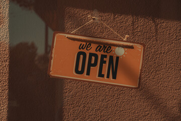 A signage that says we are open, typically used in restaurants, saloons, barbershop, cafe,  retails stores and such 