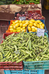Fresh bean pods, lemons, and red onions for sale at the outdoor souk in Bir al Haffay.