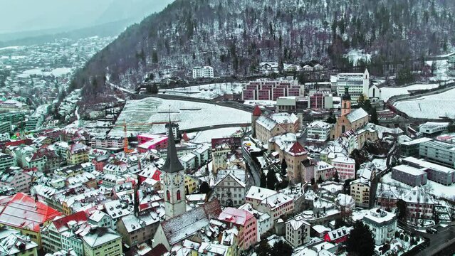 Aerial view of Alpine City Chur with a tower clock and colourful houses. The capital of the Graub&uuml;nden canton covered with snow in eastern Switzerland. 