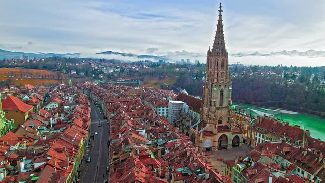 Aerial view of Aare River and Berner M&uuml;nster Cathedral in Old Town of Bern, Switzerland. Panoramic view of red rooftop houses of medieval townscape, Gothic architecture in Europe.
