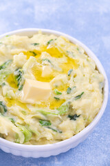 Delicious homemade Irish dish Colcannon or mashed potato with green cabbage, vertical closeup