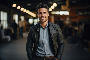 Confident Businessman in Stylish Leather Jacket Smiling in a Modern Office Environment
