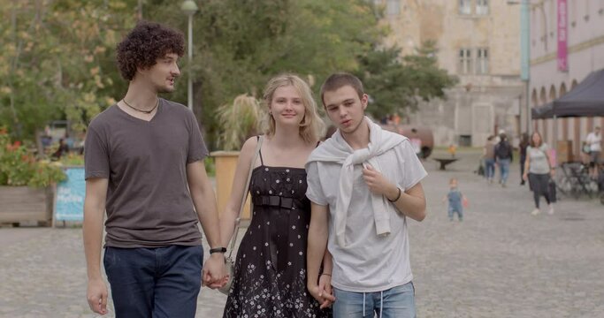 Romantic relationships among three individuals, involve consensually and openly loving, connecting with multiple partners simultaneously. People lifestyle Girl and two guys walking talking. 