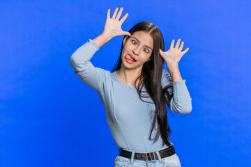 Funny comical playful young woman making silly facial expressions and grimacing, fooling around,...