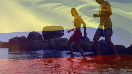 Animation of colombian flag over diverse friends running on sunny beach - Powered by Adobe