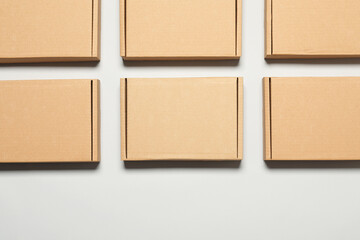 Fototapeta premium Many cardboard boxes on white background, flat lay. Packaging goods
