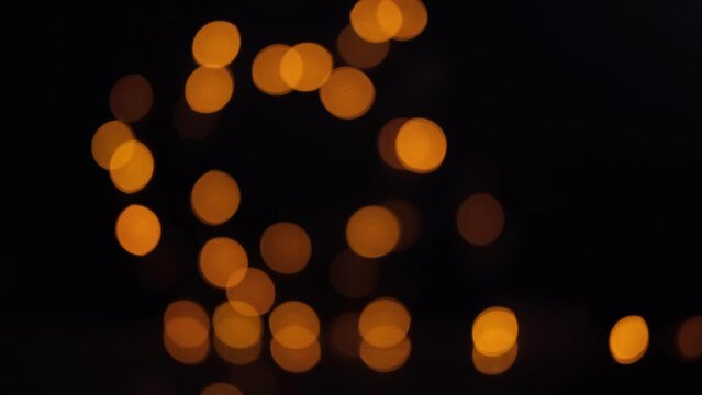 Blinking bokeh lights on isolated black background. Unfocused. Christmas fairy light.