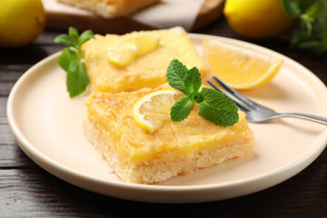 Tasty lemon bars served on wooden table, closeup
