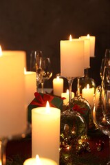 Christmas celebration. Burning candles, glasses and festive decor on table
