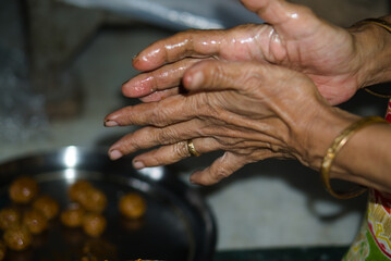 making of jaggery and seasame seed delicacy called tiler naru by hand in bengal