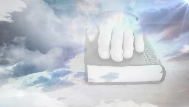 Animation of clouds and light trails over hands with book