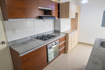 cocina de departamento con horno, muebles altos y bajos