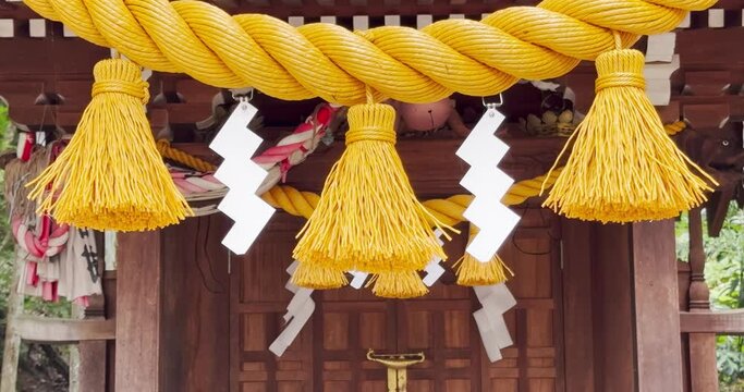 A Shimenawa lengths of laid rice straw or hemp rope used for ritual purification with Shide zigzag shaped paper streamers in the Shinto religion in Japan.