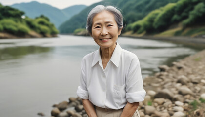 川沿いで微笑む老女。日本、アジア、シニア - obrazy, fototapety, plakaty