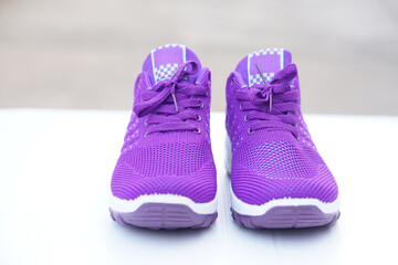 Pair of new purple sneakers. Fashionable and comfortable sport footwears. outdoor background.  Concept, shoes for doing sport or exercise also can wear for traveling, hiking.     