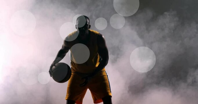 Animation of african american basketball player throwing ball and spots of light on black background
