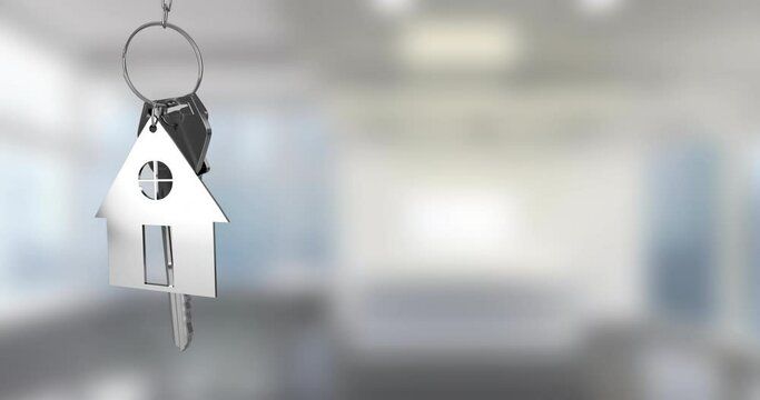 Animation of silver key with house key fob and copy space over out of focus interiors
