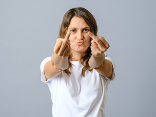 Young woman doing offensive gesture with finger over isolated